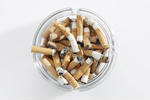 overhead-view-of-glass-ashtray-full-of-cigarette-stubs_53990446